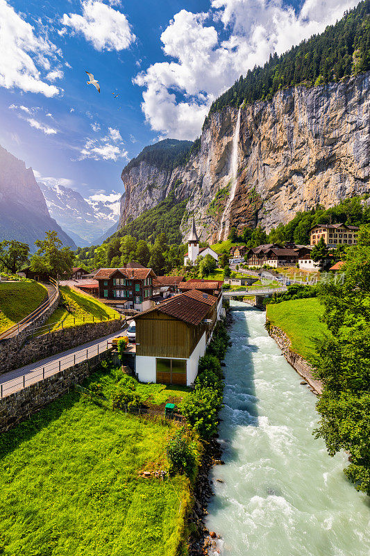高山旅游村庄Lauterbrunnen令人惊叹的夏季景观，著名的教堂和Staubbach瀑布。地点:Lauterbrunnen村，Berner Oberland，瑞士，欧洲。